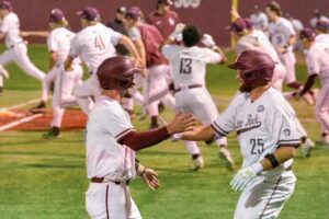 Two man in athletic clothing high five each other.