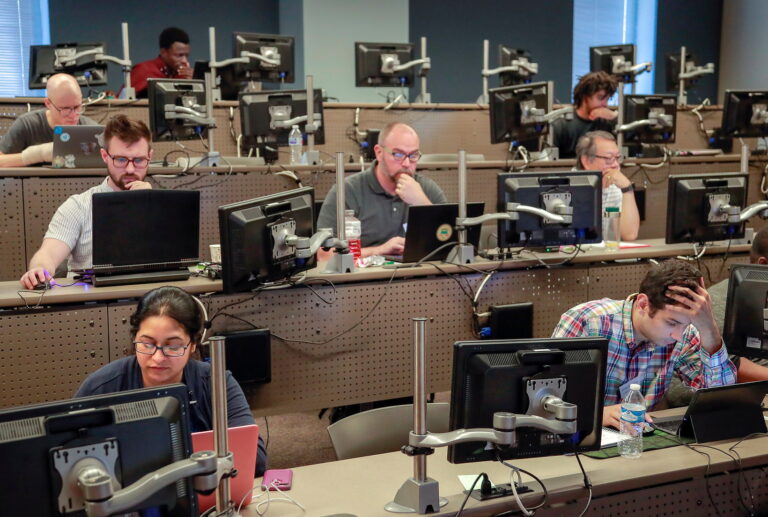 Group of people participating in a workshop in a computer lab.